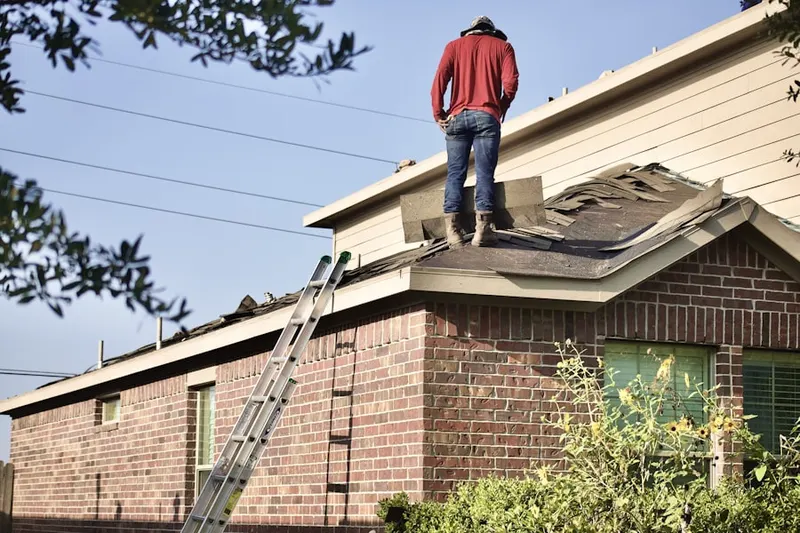 Professional roofer working on a residential roof in Huntington Farms